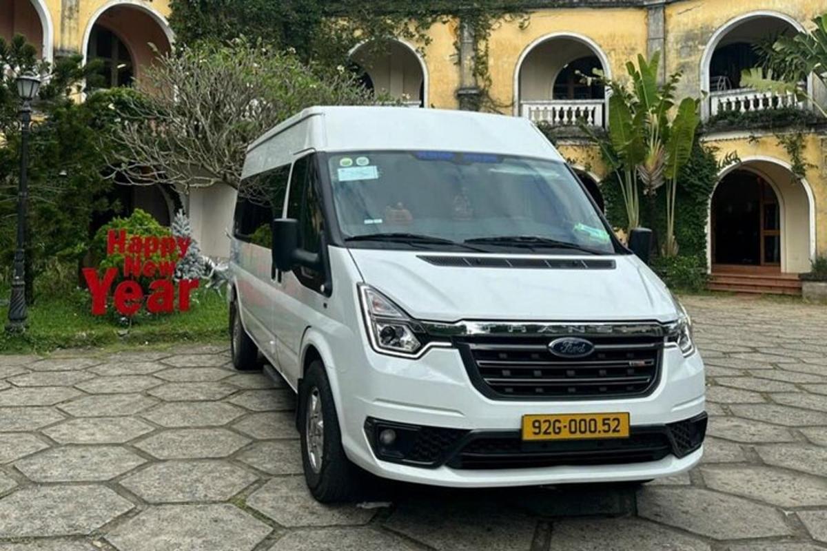 uma van branca estacionada em frente a um prédio