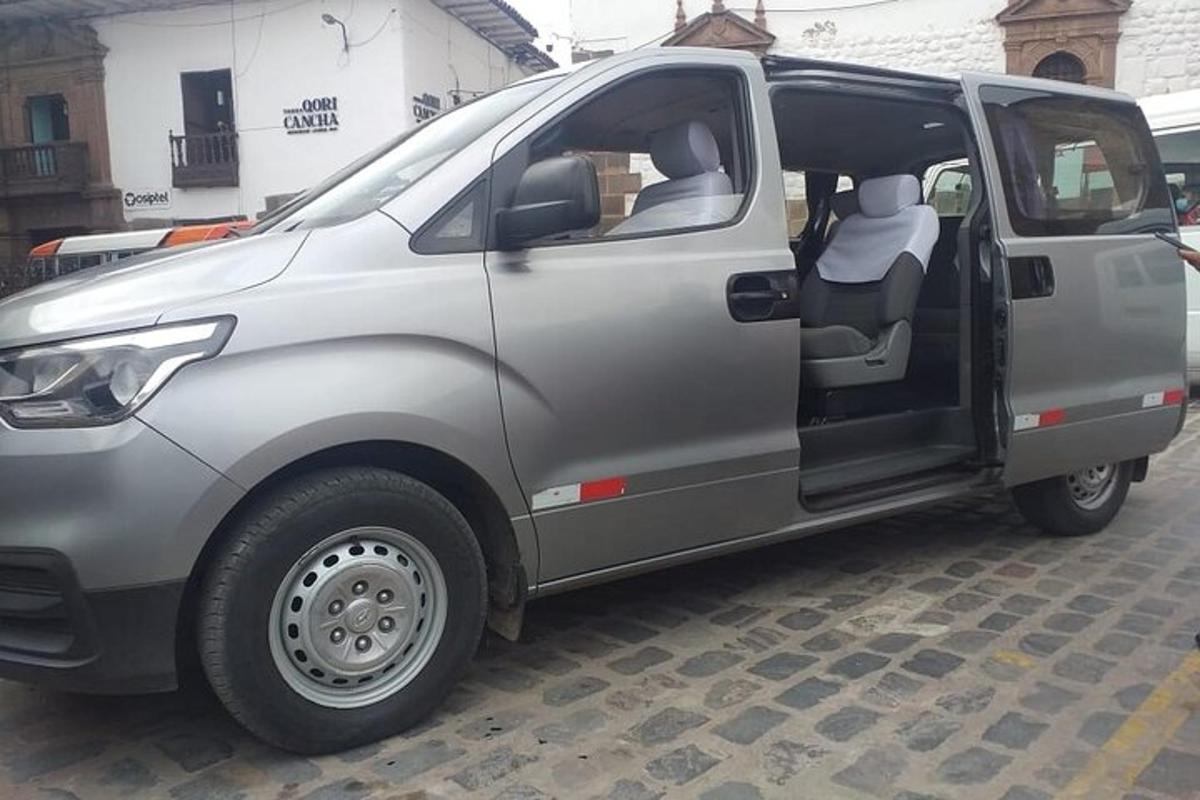 a silver van with its door open on a street