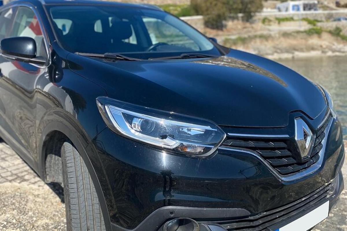 un'auto blu parcheggiata accanto a uno specchio d'acqua