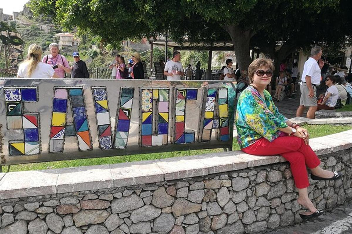 isang babaeng nakaupo sa isang dingding na may mga stained glass na bintana