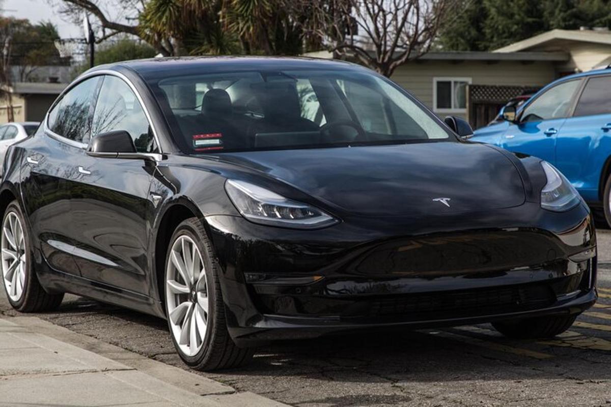 un cotxe Tesla negre aparcat en un aparcament
