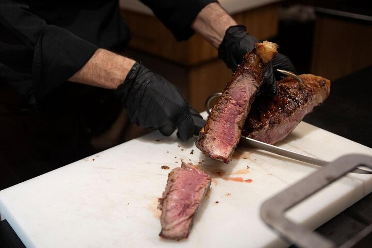 a person cutting a piece of meat with a knife
