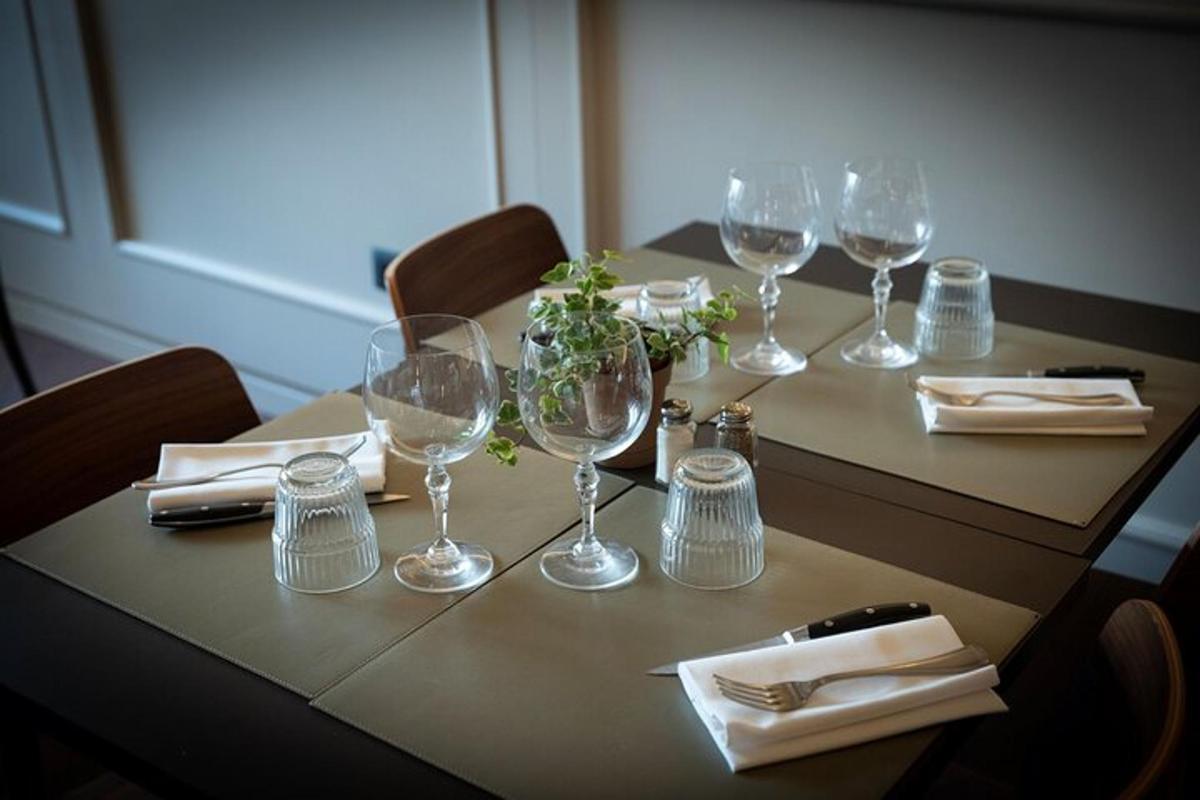 Una mesa con copas de vino y servilletas encima.