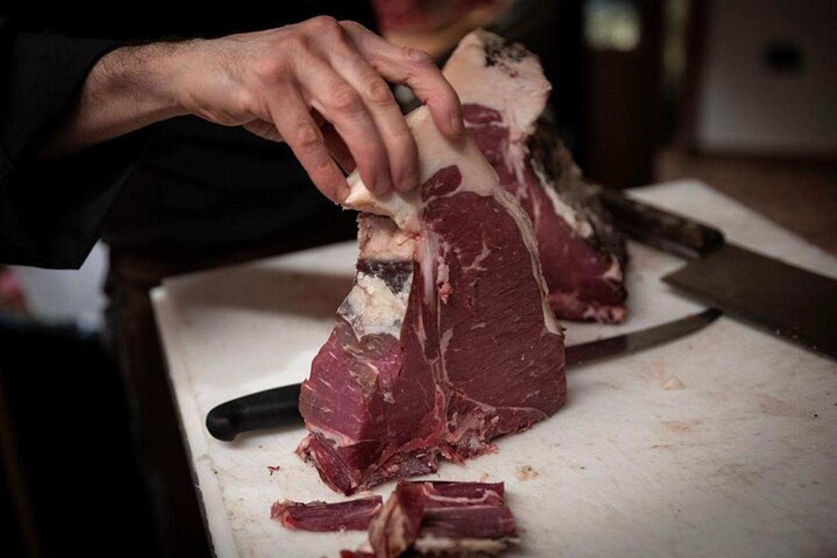 una persona cortando un trozo de carne con un cuchillo