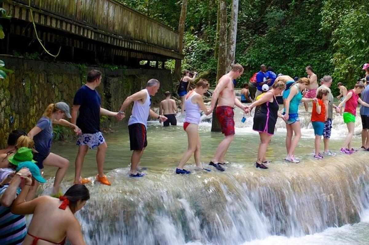 un gruppo di persone in piedi in cima a una cascata