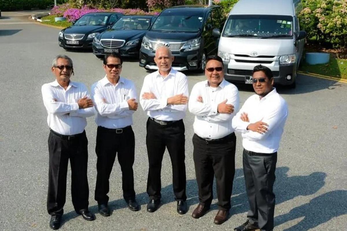 sekumpulan lelaki berdiri di tempat letak kereta