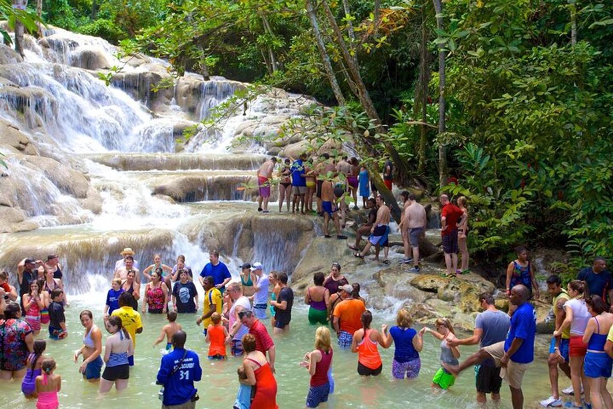 un gruppo di persone in piedi nell'acqua vicino a una cascata