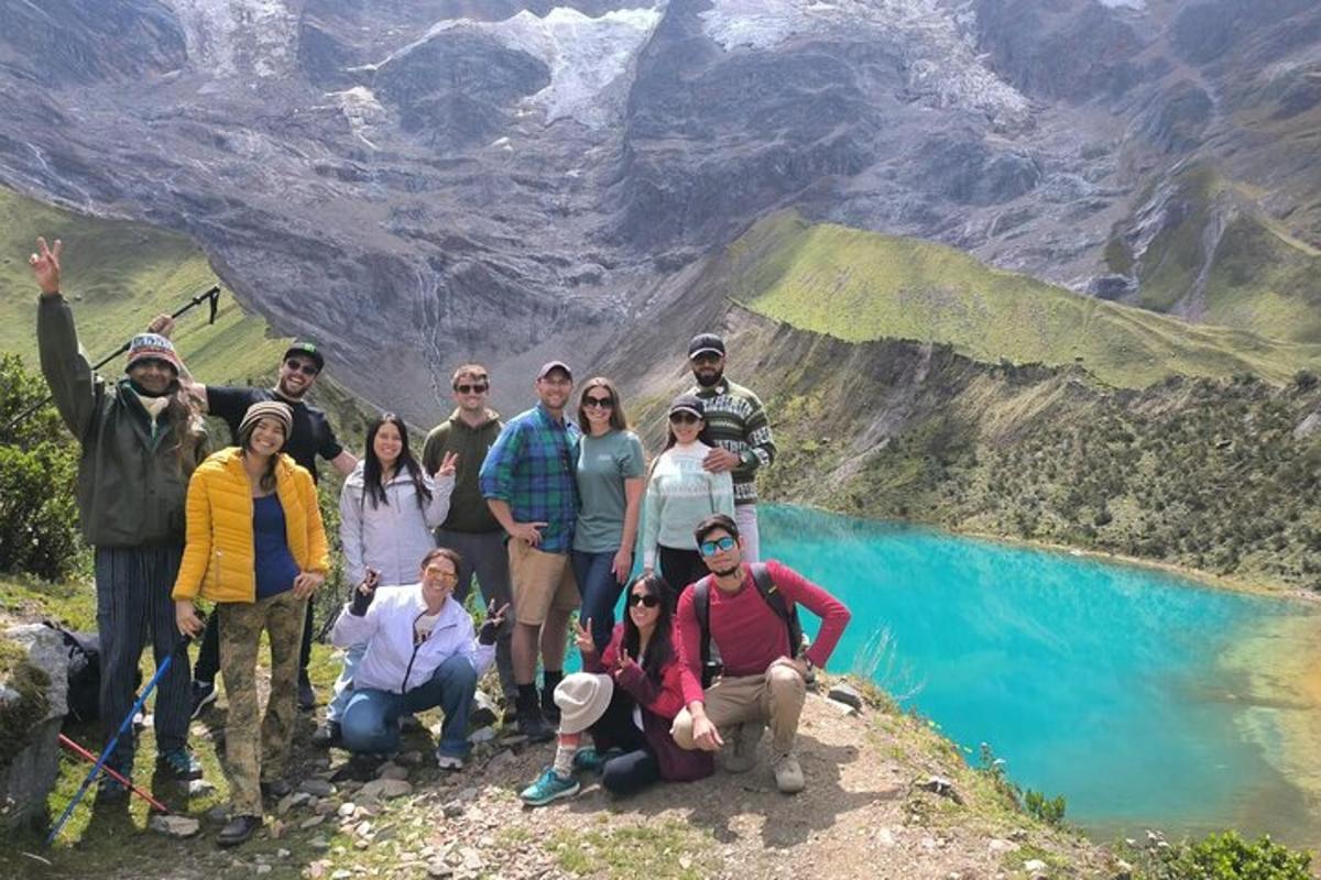 sekelompok orang berpose untuk foto di depan gunung