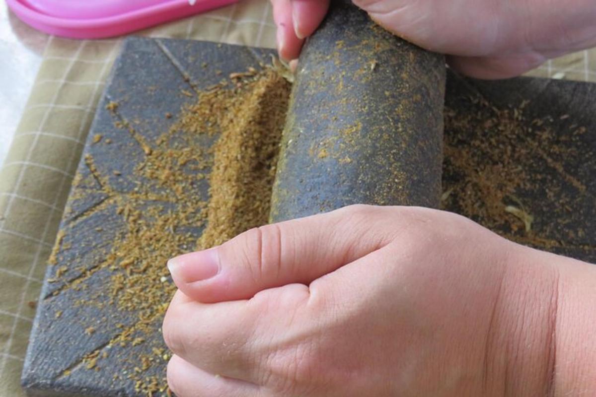 một người cầm một con dao có đất trên thớt
