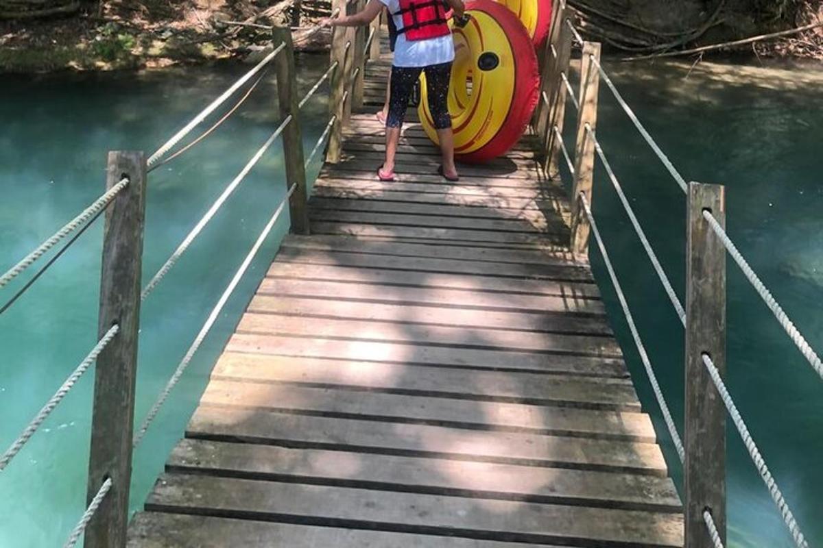 un ragazzo in piedi su un ponte di legno sopra l'acqua