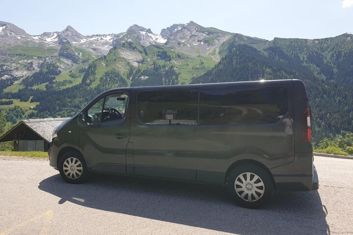 Una camioneta verde estacionada frente a una montaña