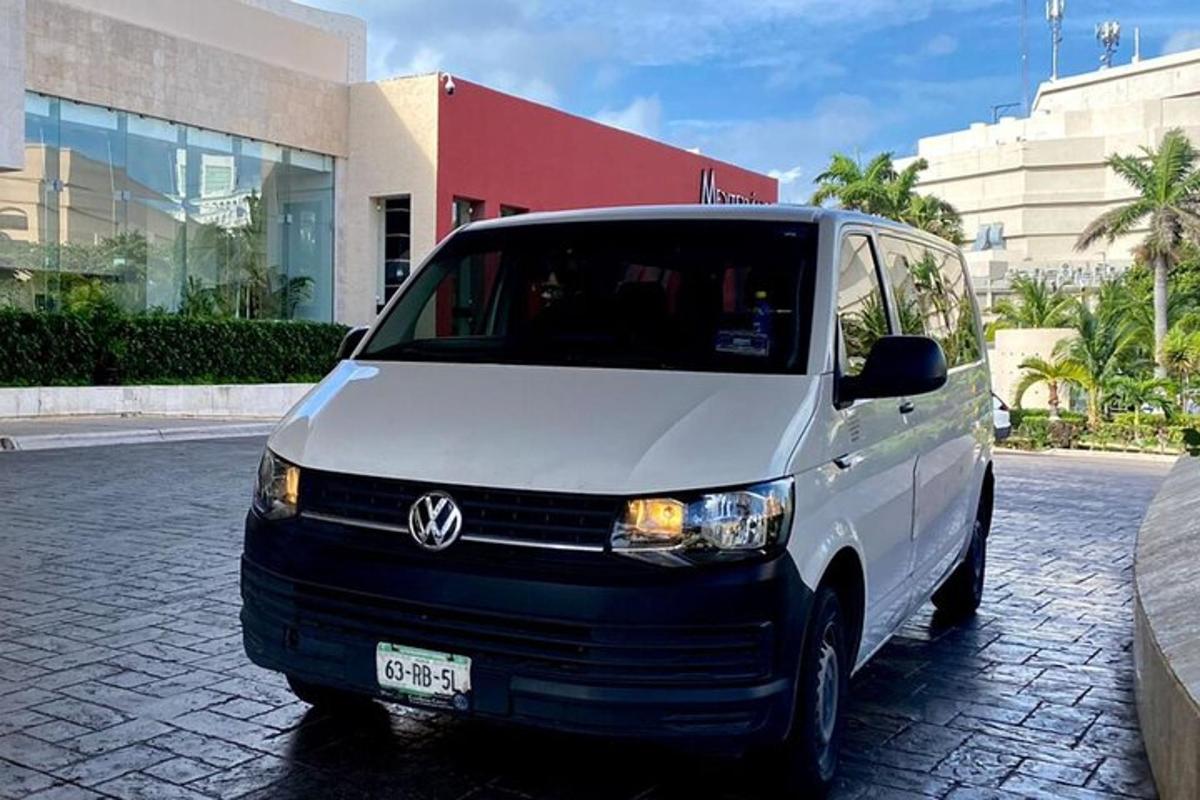 Una camioneta blanca estacionada en una calle frente a un edificio.