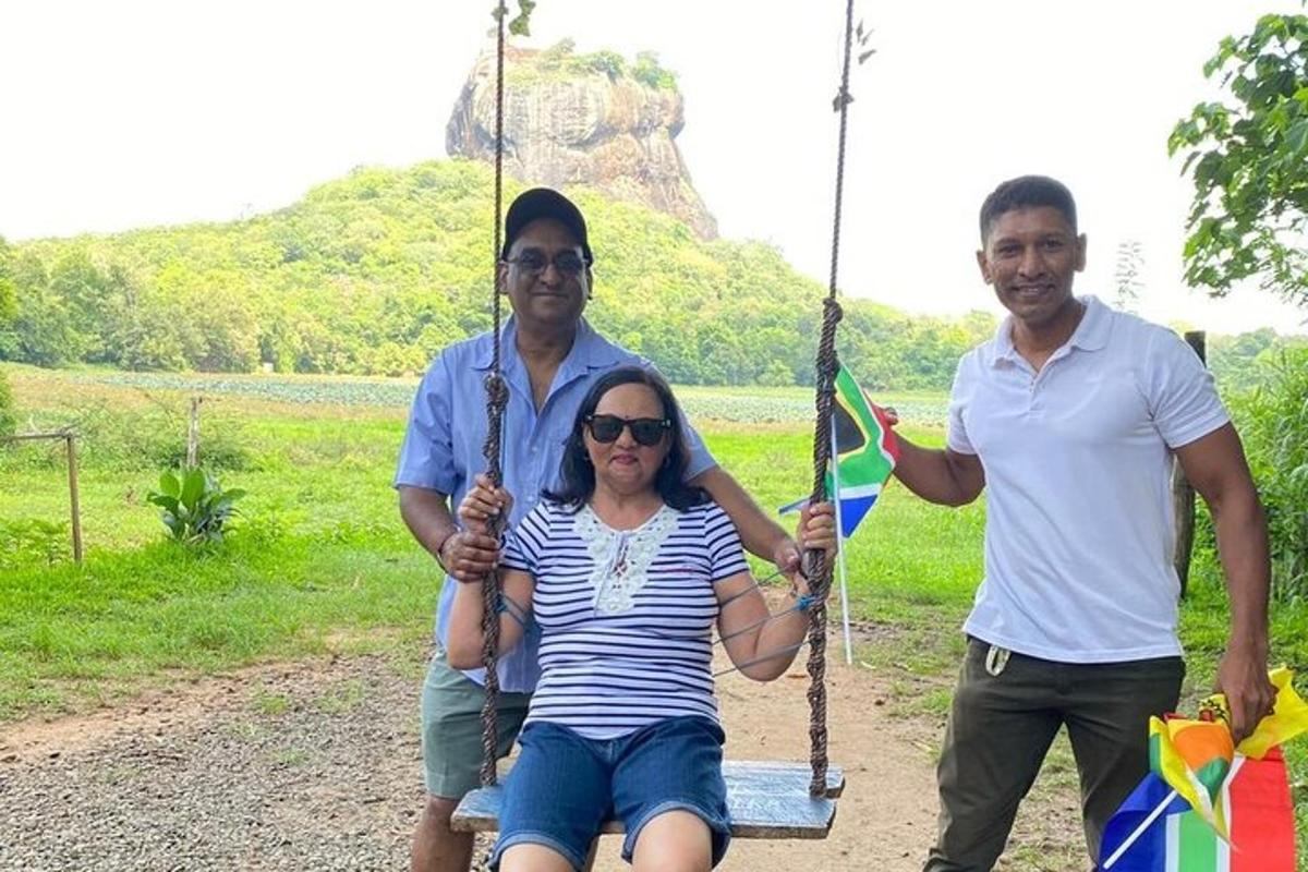 two men and a woman sitting on a swing