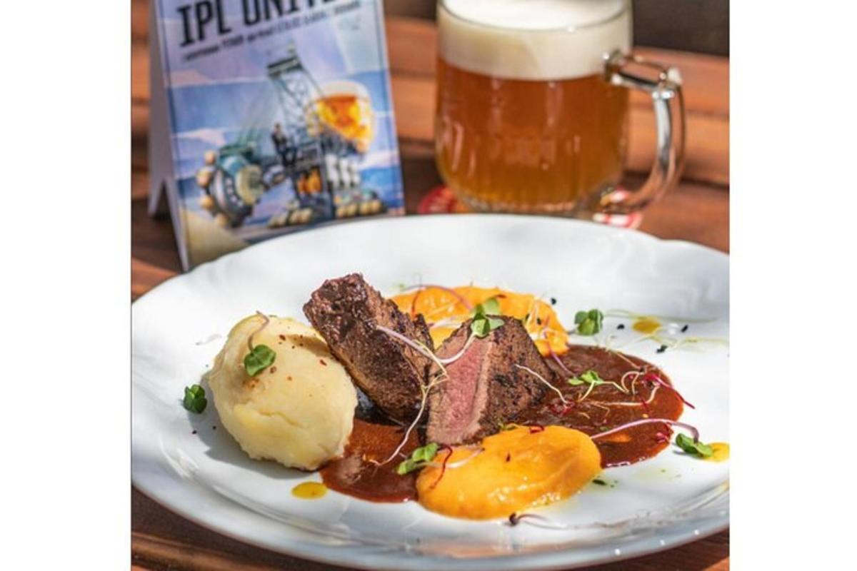 un piatto di cibo su un tavolo con un boccale di birra