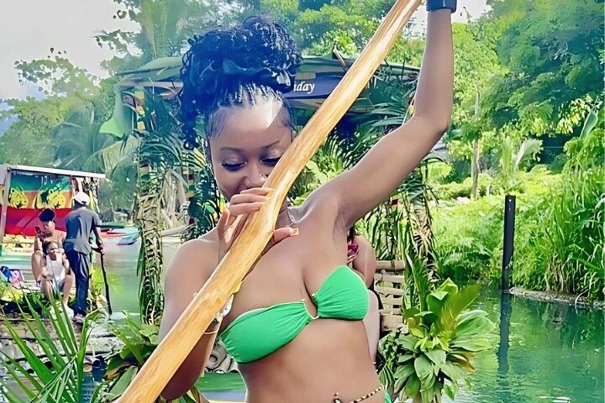 una donna in bikini verde che tiene in mano uno specchio