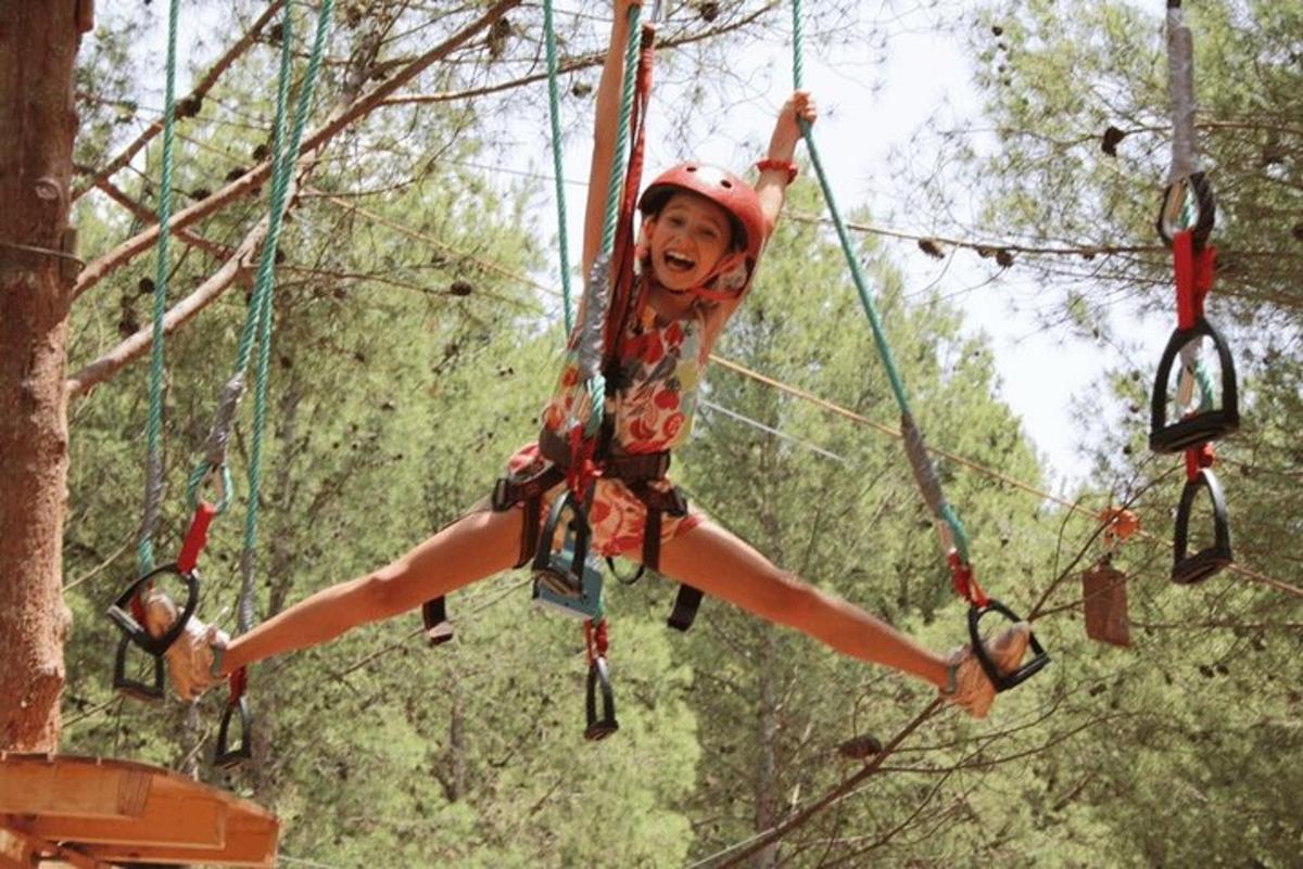 a young girl is swinging on a zip line