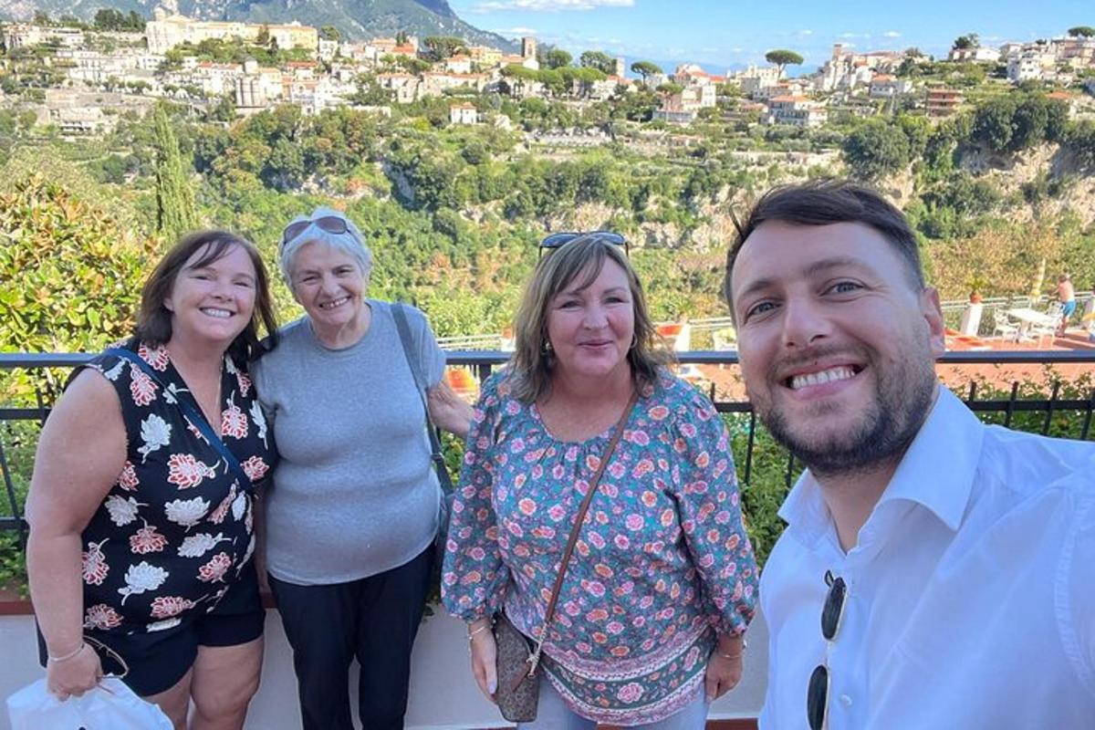 un grup de trei femei și un bărbat care stau pe un balcon