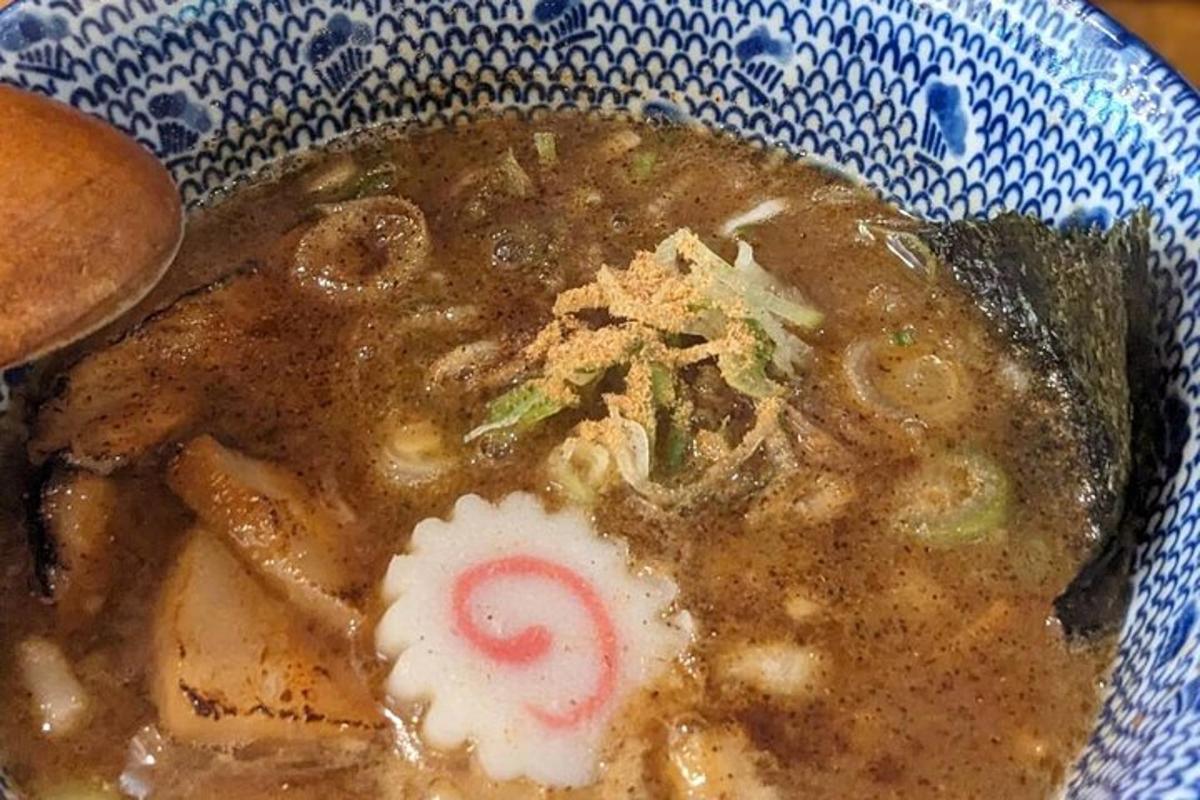 a bowl of soup with a red and white object in it