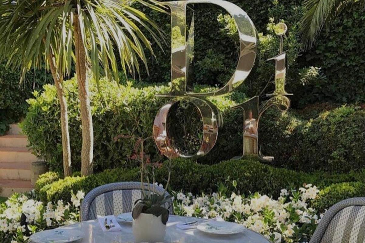 un tavolo con sedie e uno specchio in un giardino