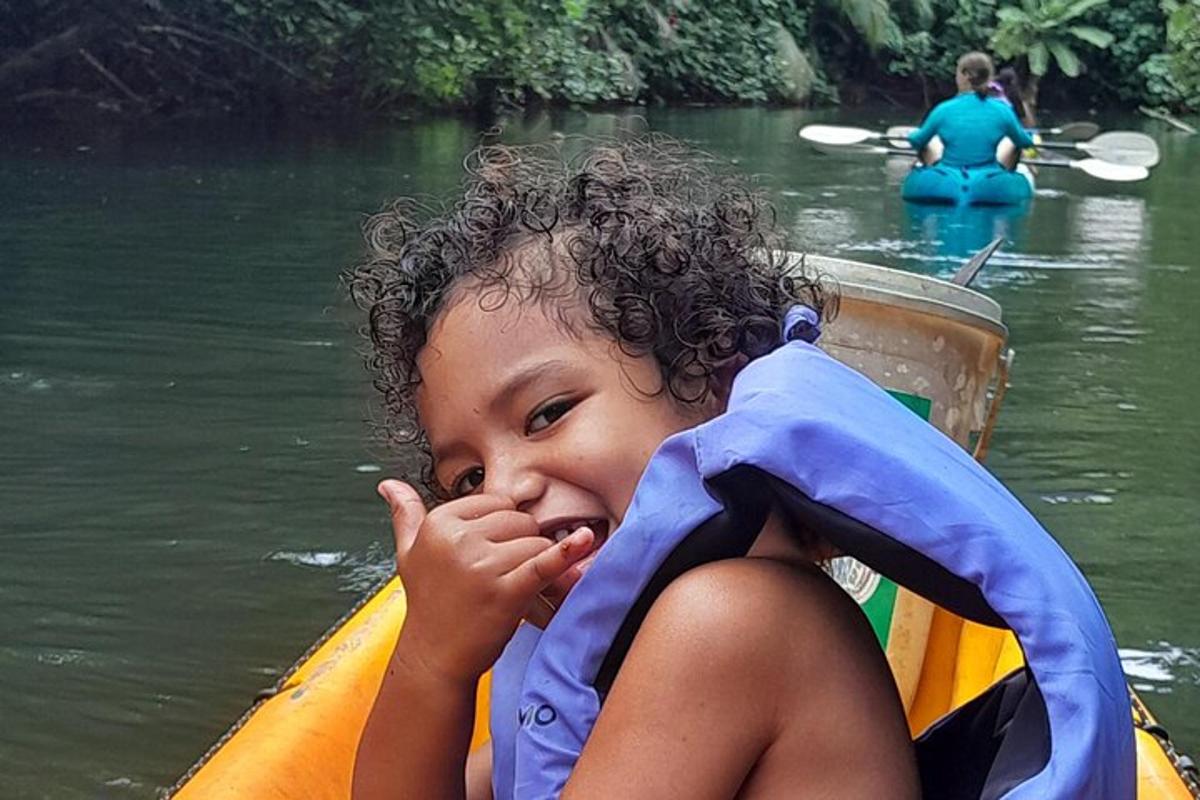 une petite fille assise dans un radeau dans l'eau