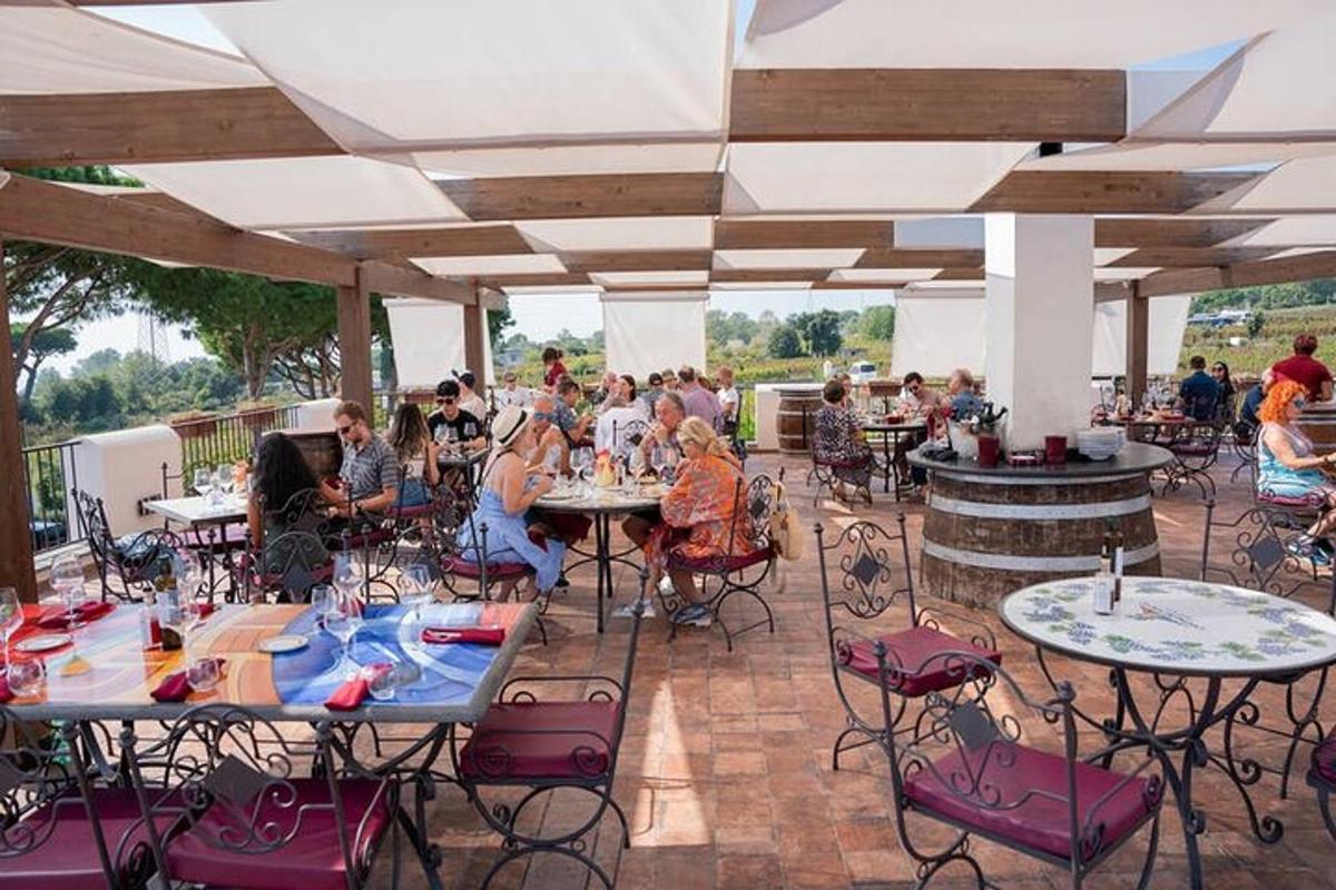 eine Gruppe von Menschen sitzt an Tischen auf einer Terrasse