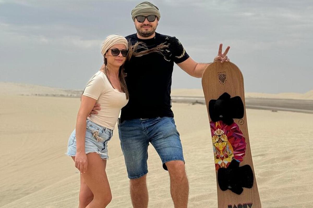 muž a žena stojící na pláži se skateboardem