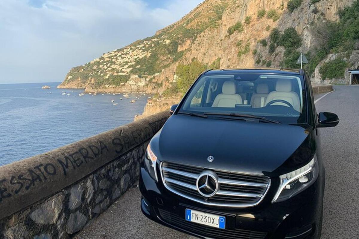 čierne auto Mercedes Benz zaparkované pri oceáne