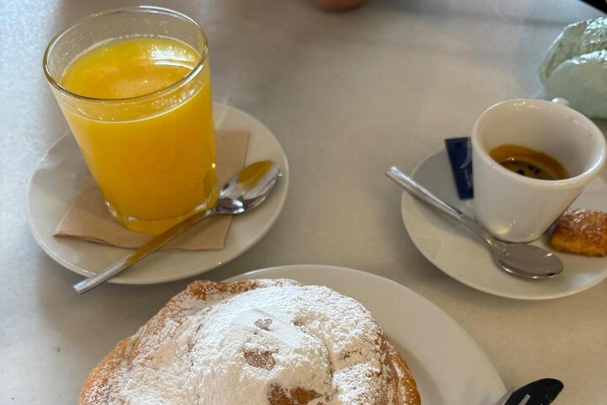miza z dvema krožnikoma hrane in kozarcem pomarančnega soka