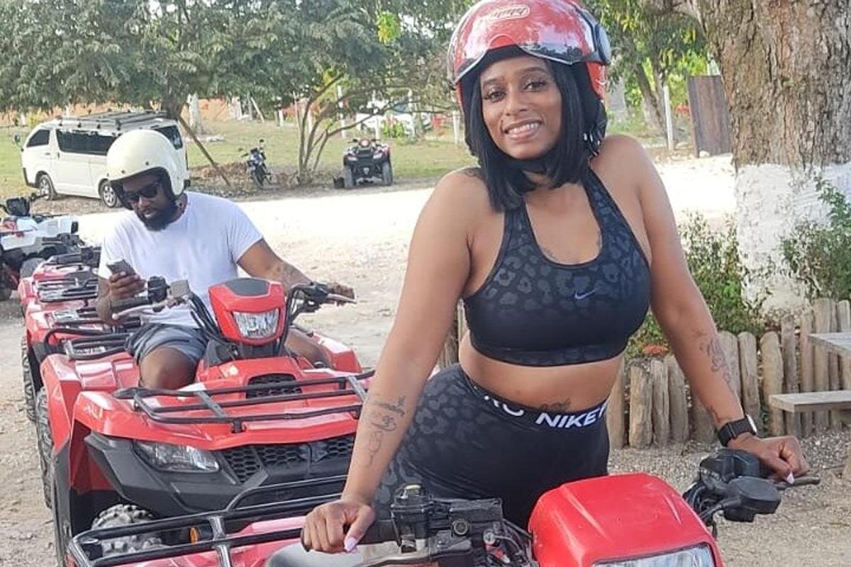 a woman in a bikini standing next to a motorcycle