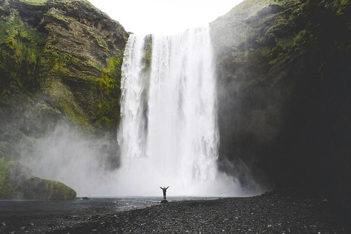una persona in piedi davanti a una cascata