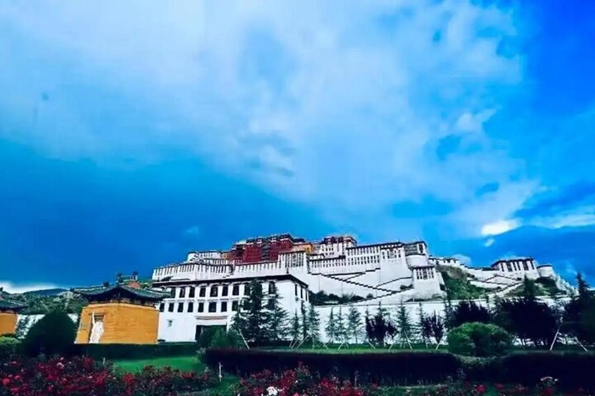 a large white building on a hill with a blue sky