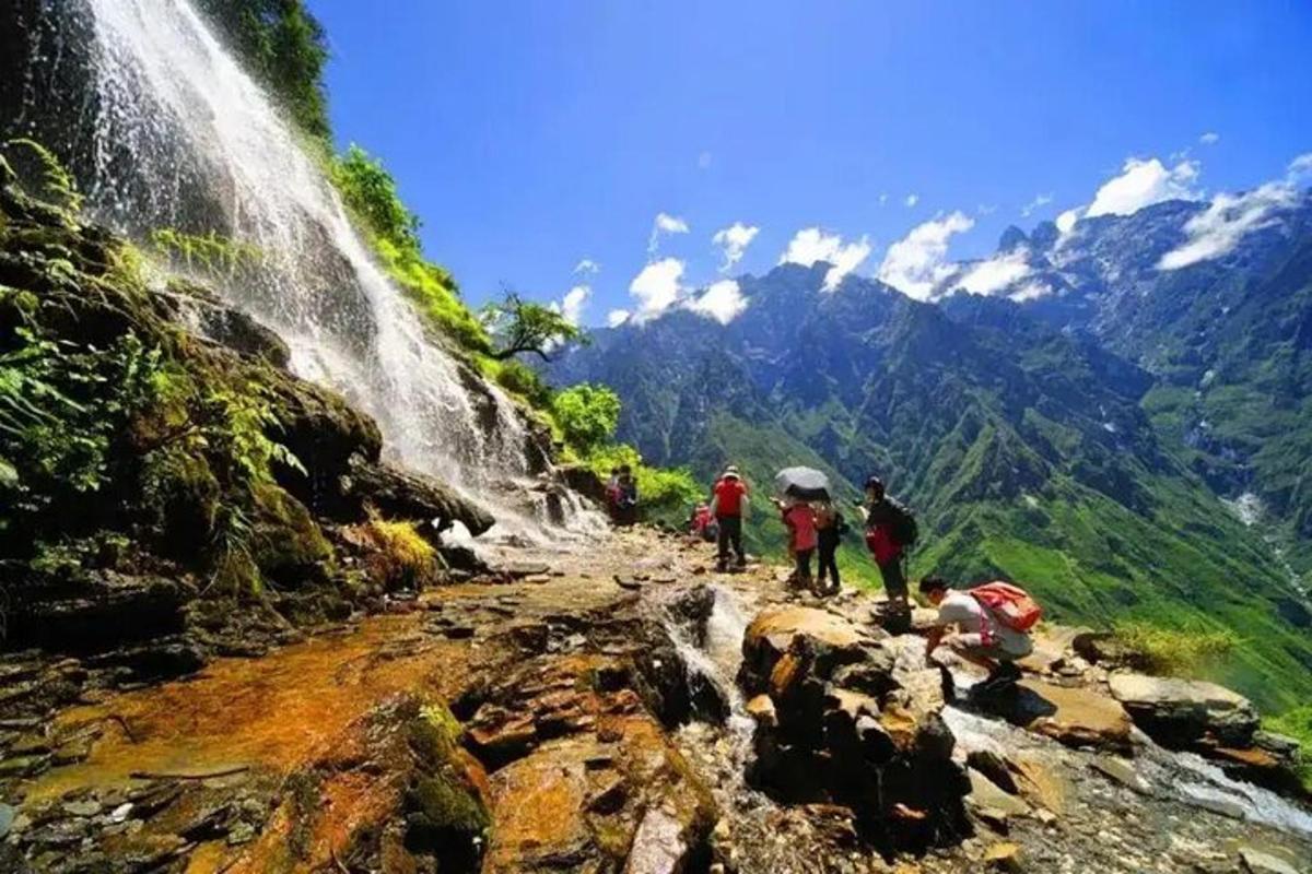 a group of people on a mountain with a waterfall