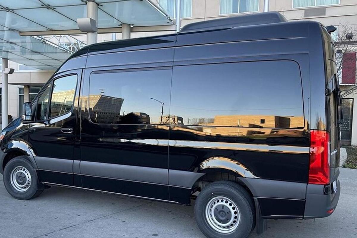 a black van with its door open with the reflection of a building