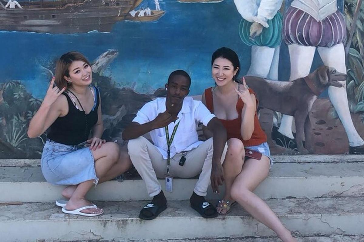 tre donne e un uomo seduti sui gradini davanti a un murale