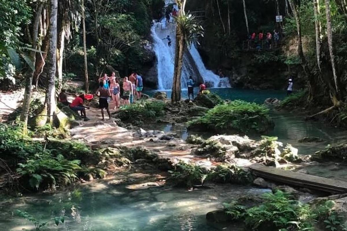 un gruppo di persone in piedi davanti a una cascata