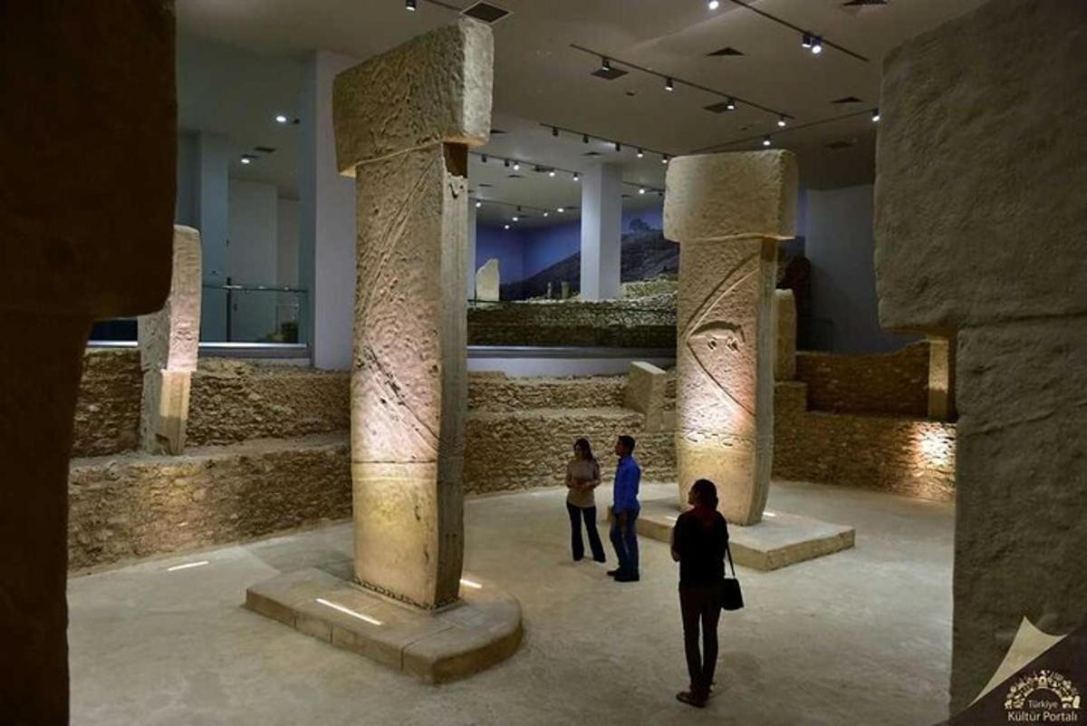 two people walking through a museum with columns