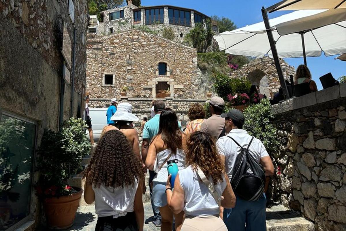 un gruppo di persone che camminano lungo un edificio in pietra