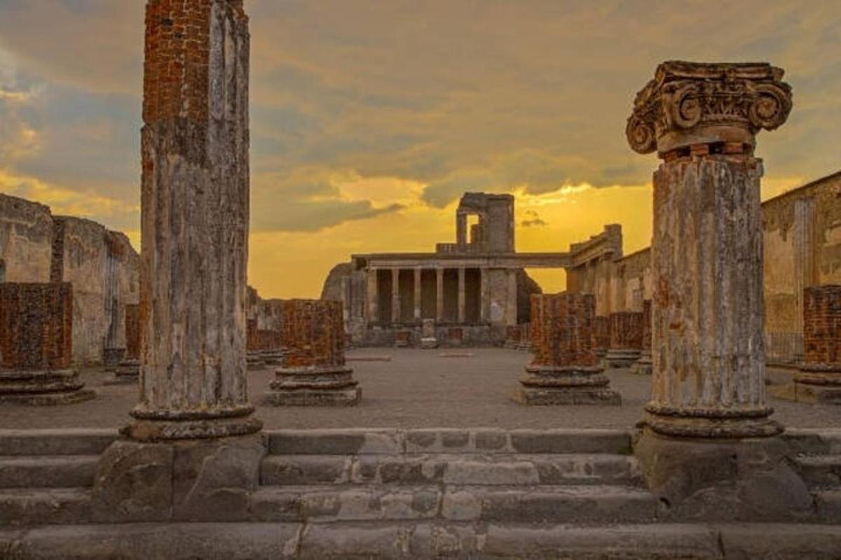 un gruppo di colonne con un edificio sullo sfondo