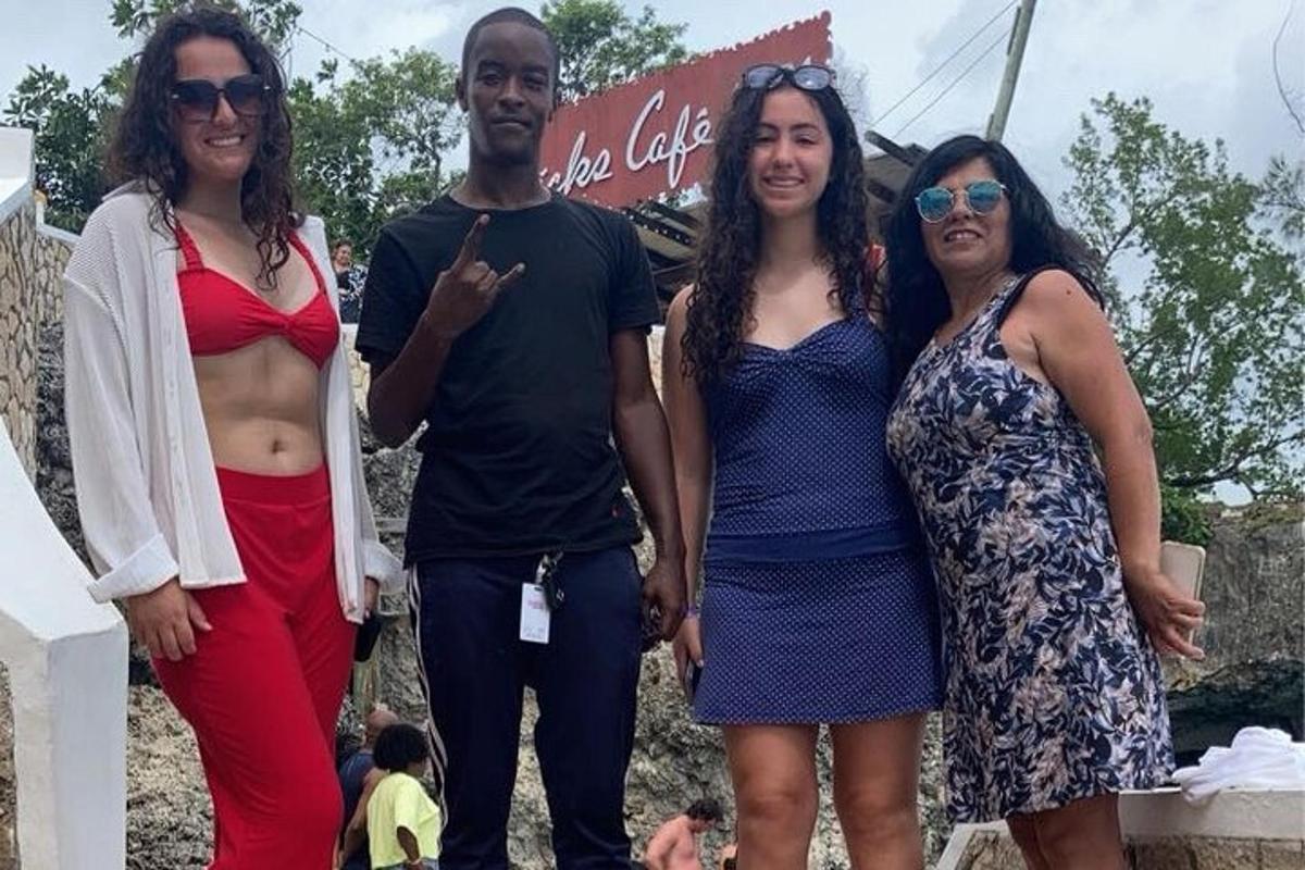 een groep van drie vrouwen en een man poseren voor een foto