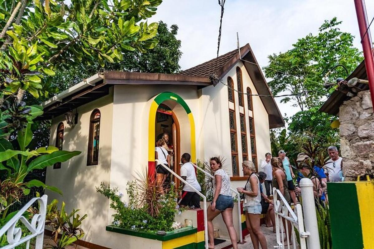 isang grupo ng mga tao na nakatayo sa labas ng isang maliit na bahay