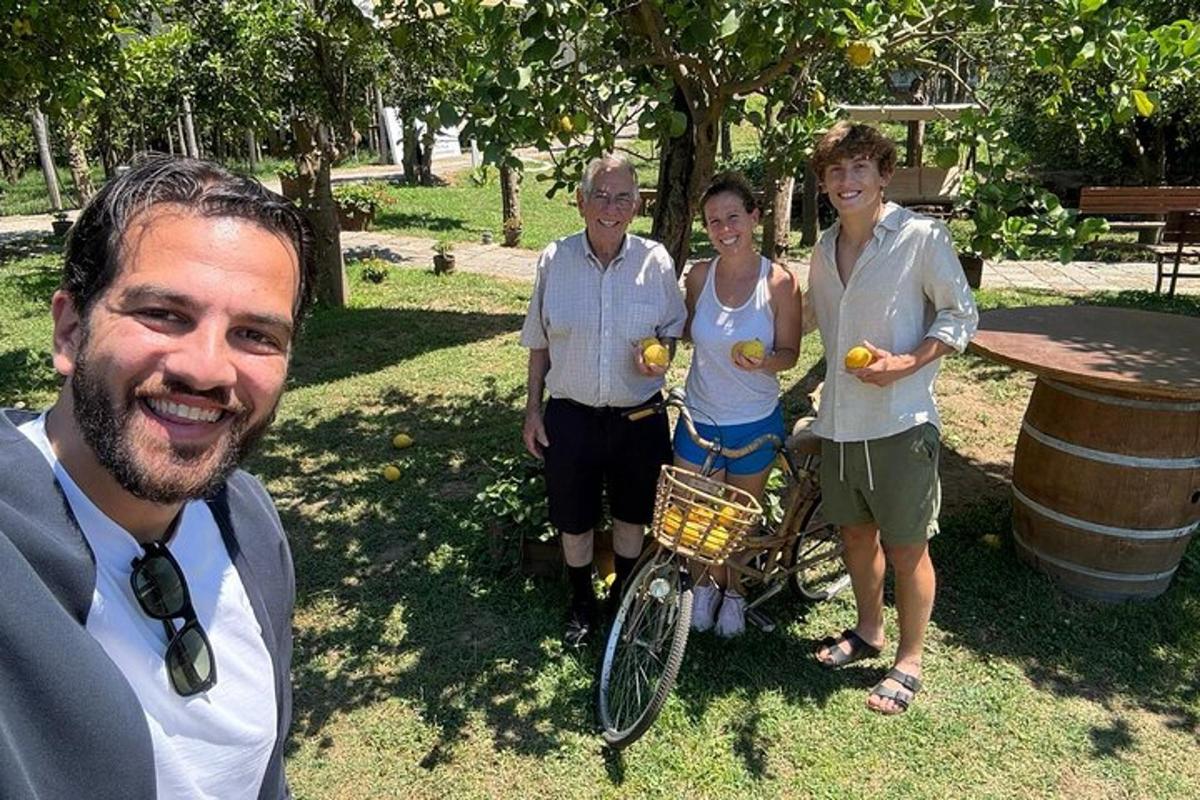 skupina lidí stojící vedle muže držícího pomeranče