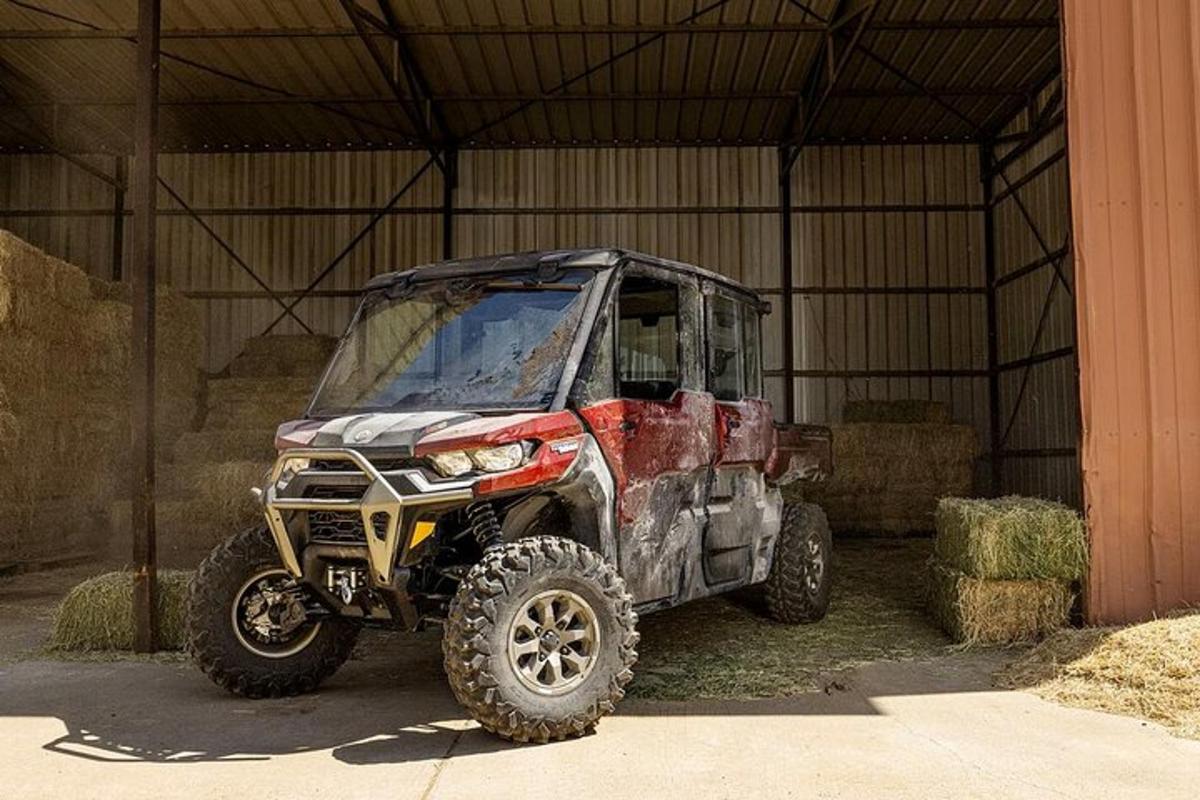 an atv parked inside of a building with hay