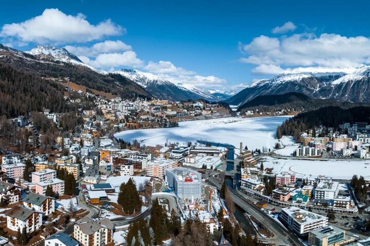 an aerial view of a city with snow covered mountains