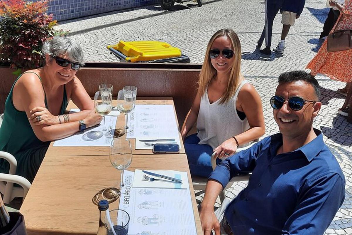 un gruppo di persone sedute a un tavolo con bicchieri di vino