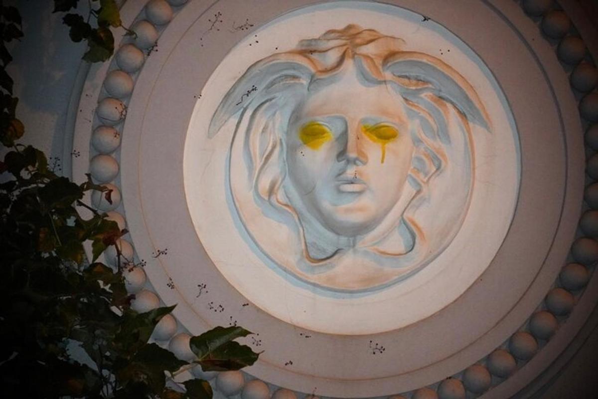 a painting of a face with yellow eyes on a frisbee