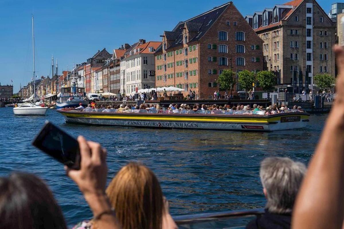 egy csoport ember fényképez egy hajót a vízen