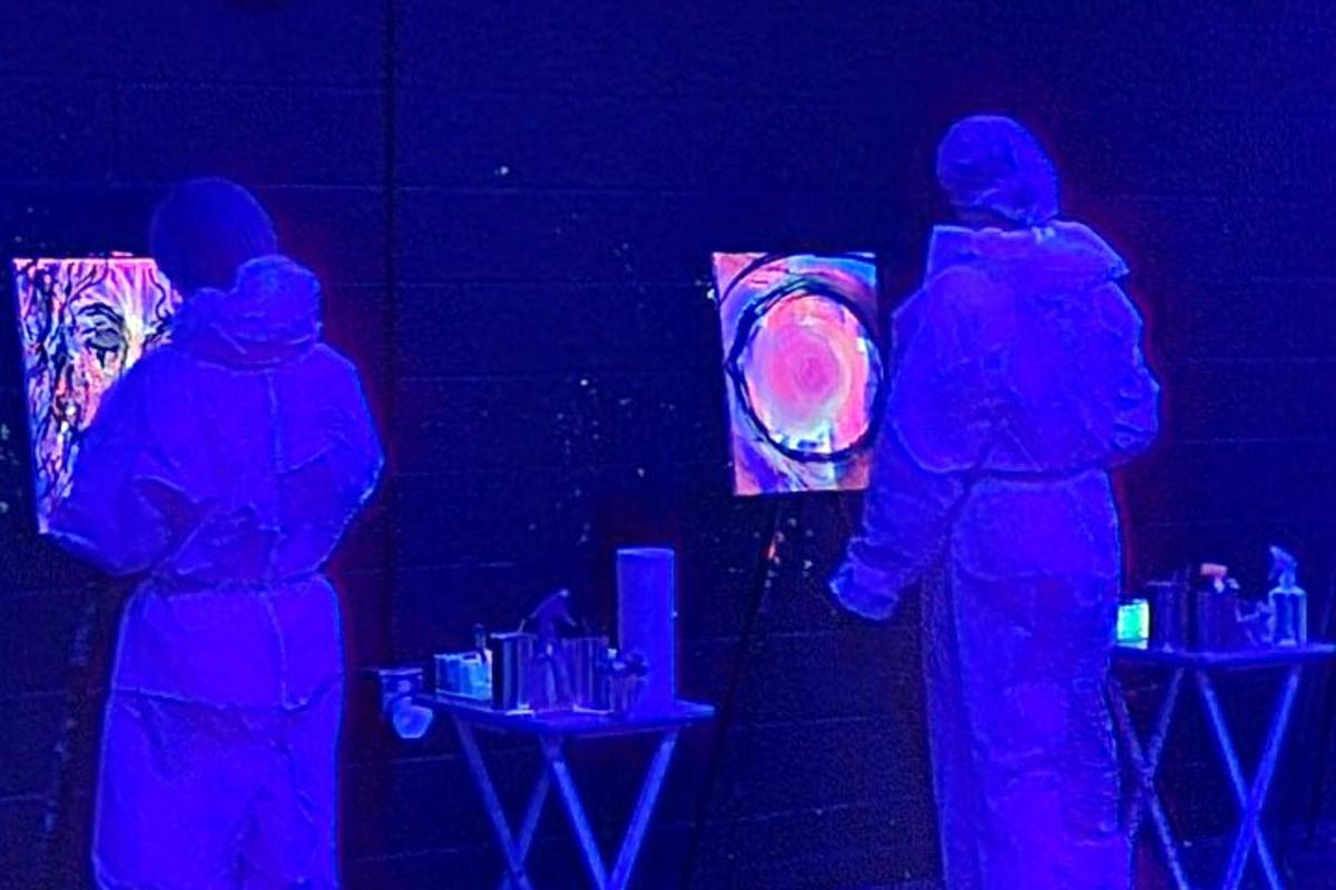 a group of three people standing in a dark room