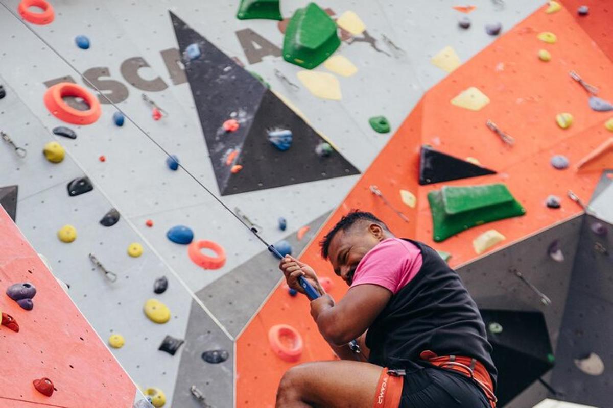 un uomo seduto su una parete da arrampicata