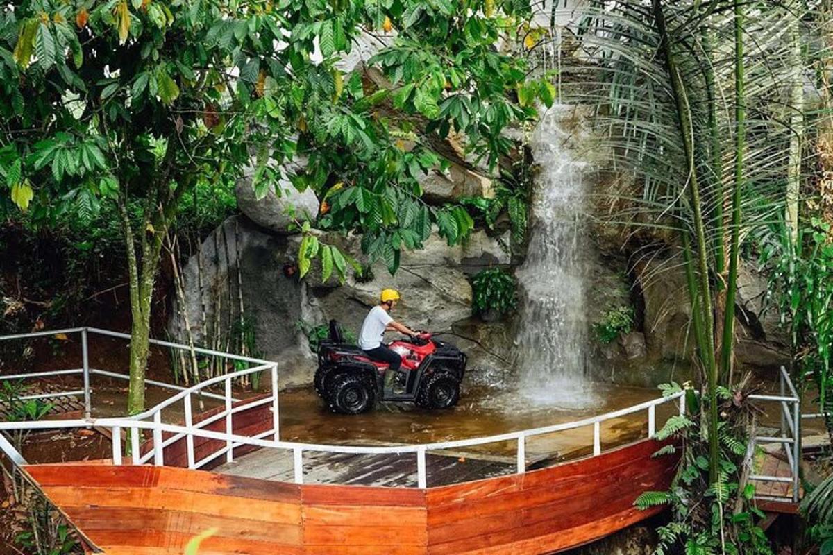 a man riding a quad bike in front of a waterfall