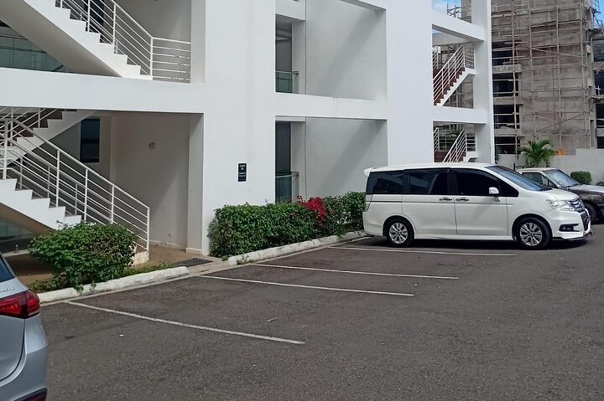 una furgoneta blanca aparcada en un aparcament davant d'un edifici